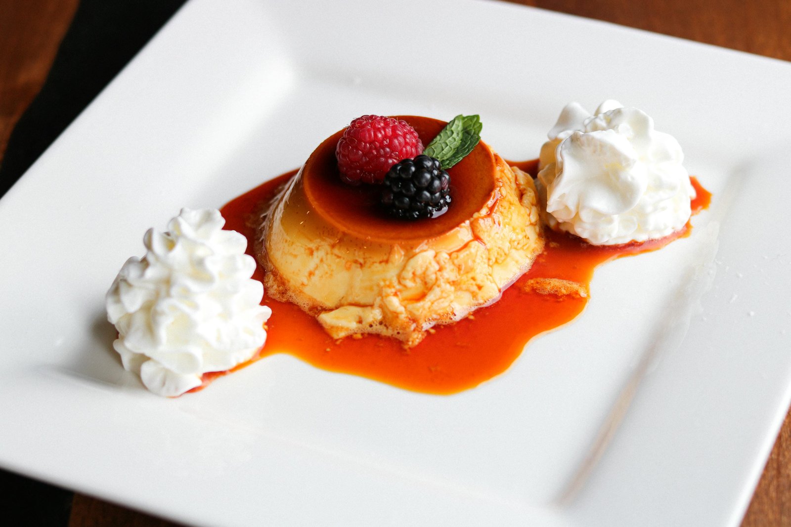 Traditional flan with caramel sauce, fresh raspberry, blackberry, and mint at Tequila Fuego Mexican restaurant Longview