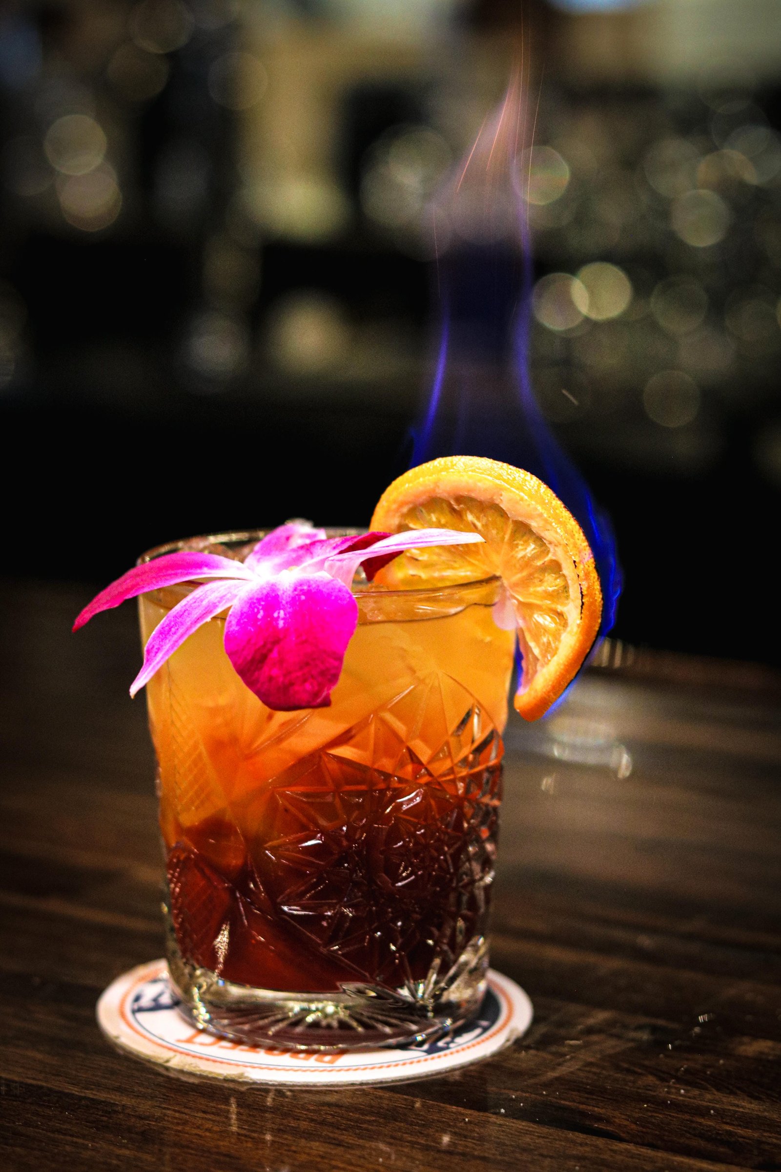 Caribbean margarita with orchid garnish and flaming orange slice, happy hour Tequila Fuego Longview.