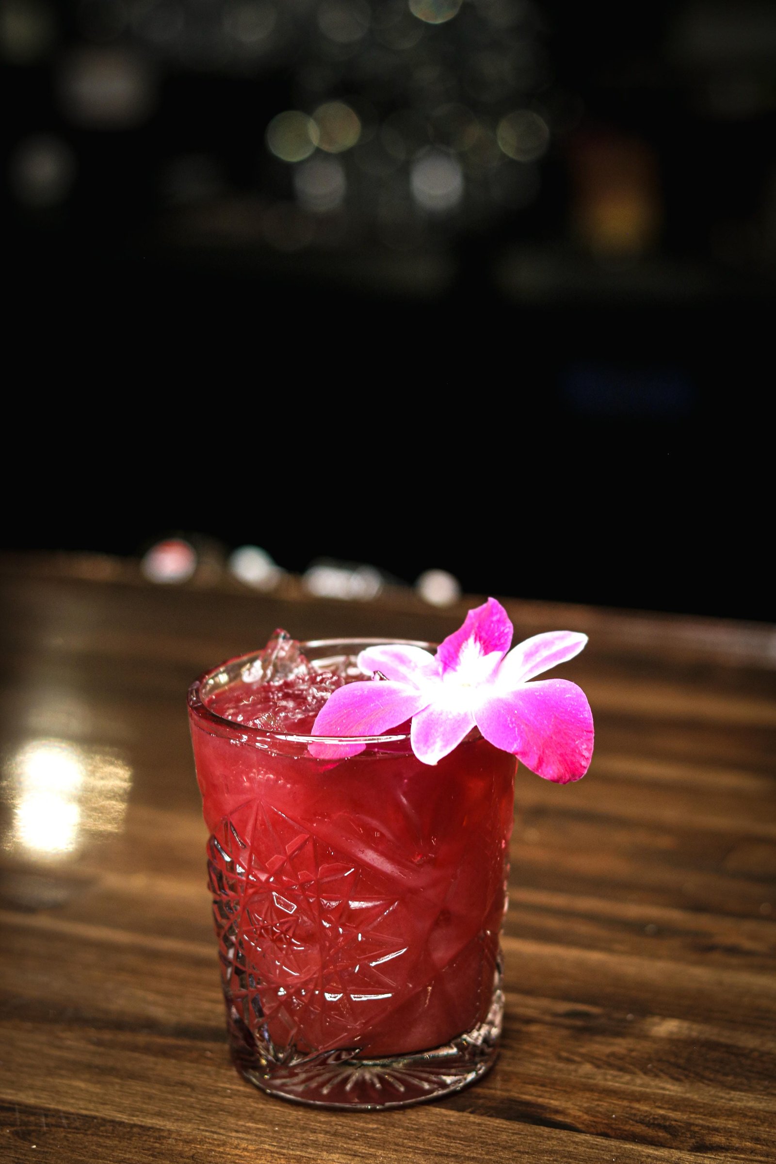 Red sangria with ice and orchid garnish, happy hour Tequila Fuego Longview.