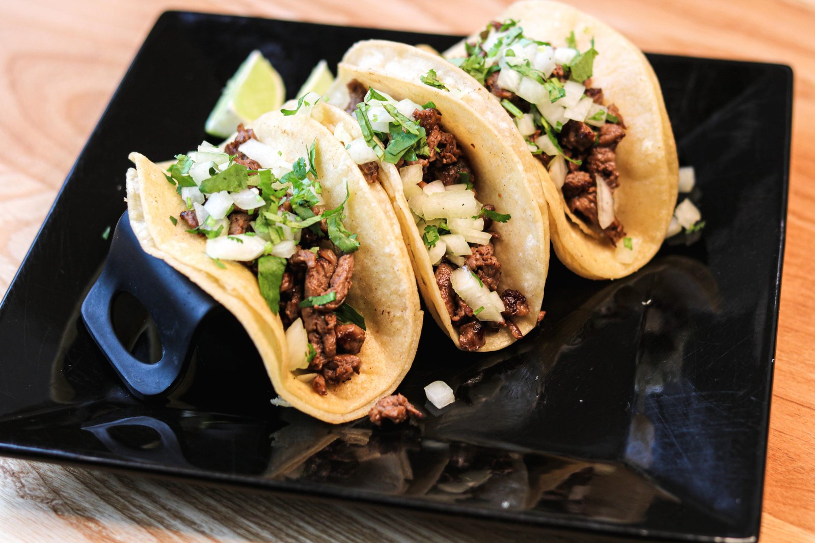 Three street tacos with cilantro and onion; choice of carne asada, pollo, or al pastor, happy hour Tequila Fuego Longview.