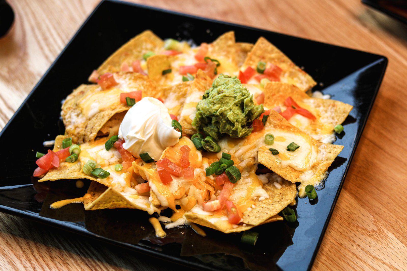Super nachos with melted cheese, guacamole, sour cream, and tomatoes, Tequila Fuego happy hour Longview WA.