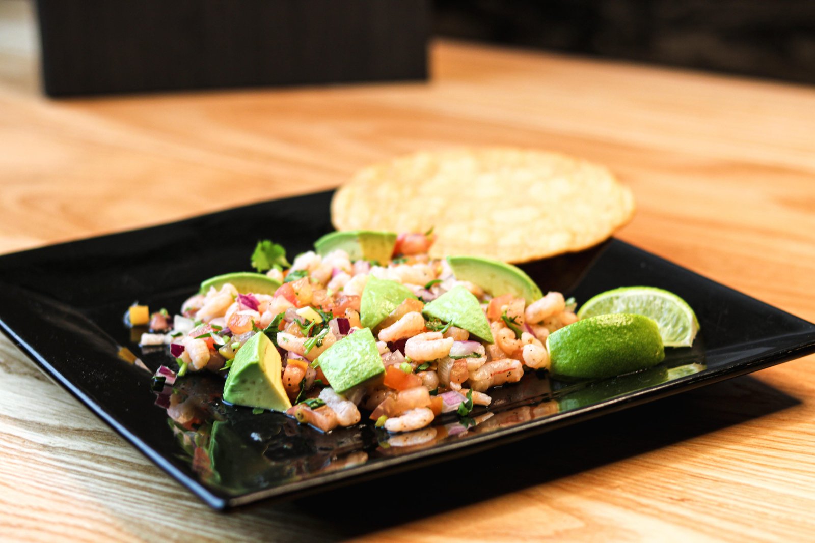 Tostada ceviche with avocado, lime wedges, and a crisp tostada, Tequila Fuego happy hour Longview.
