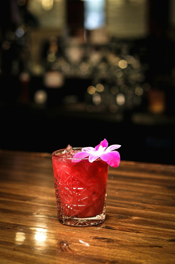 Red cocktail with orchid garnish at Tequila Fuego bar Longview